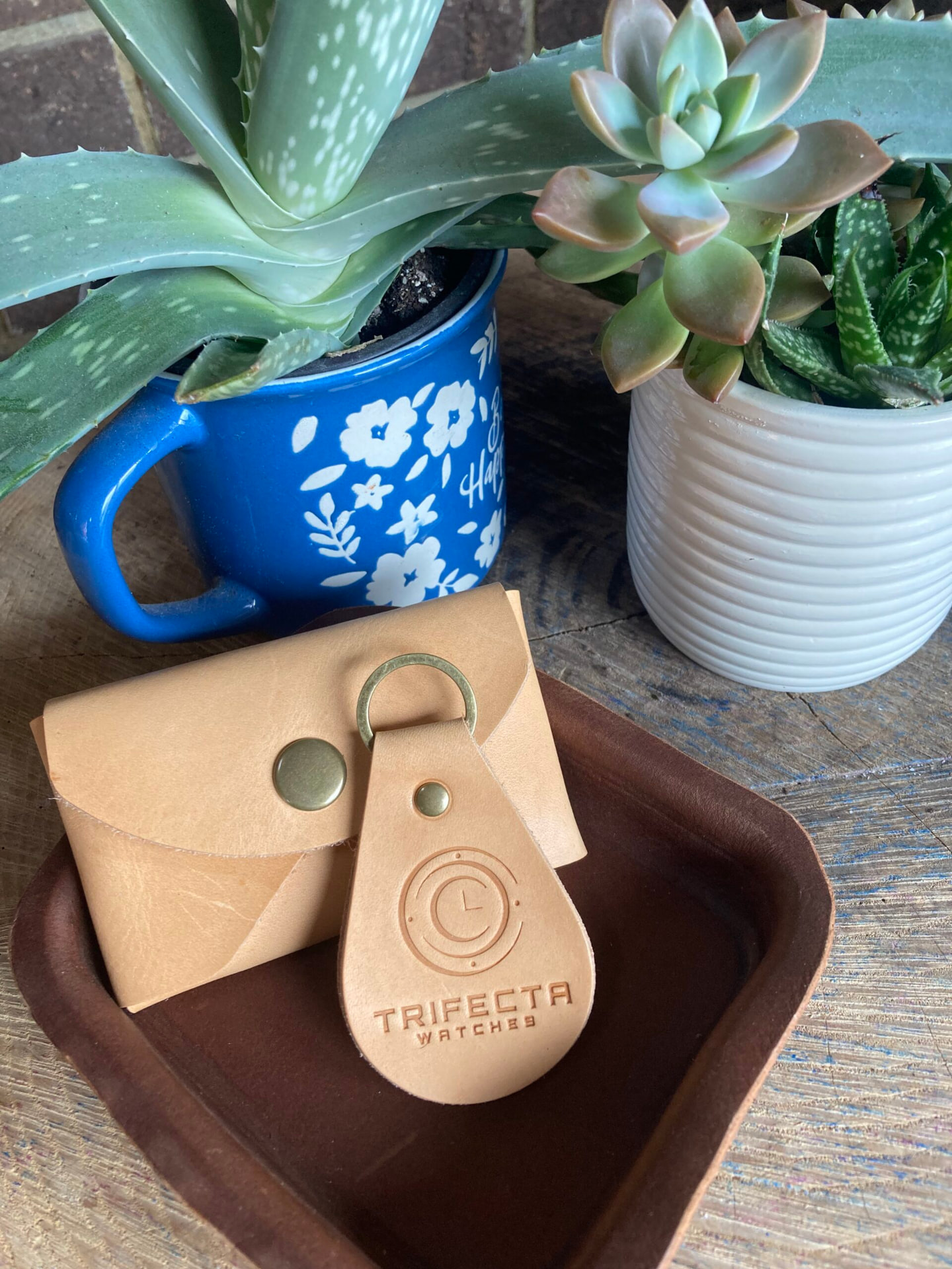 Custom logo-stamped leather keychain resting on a leather tray