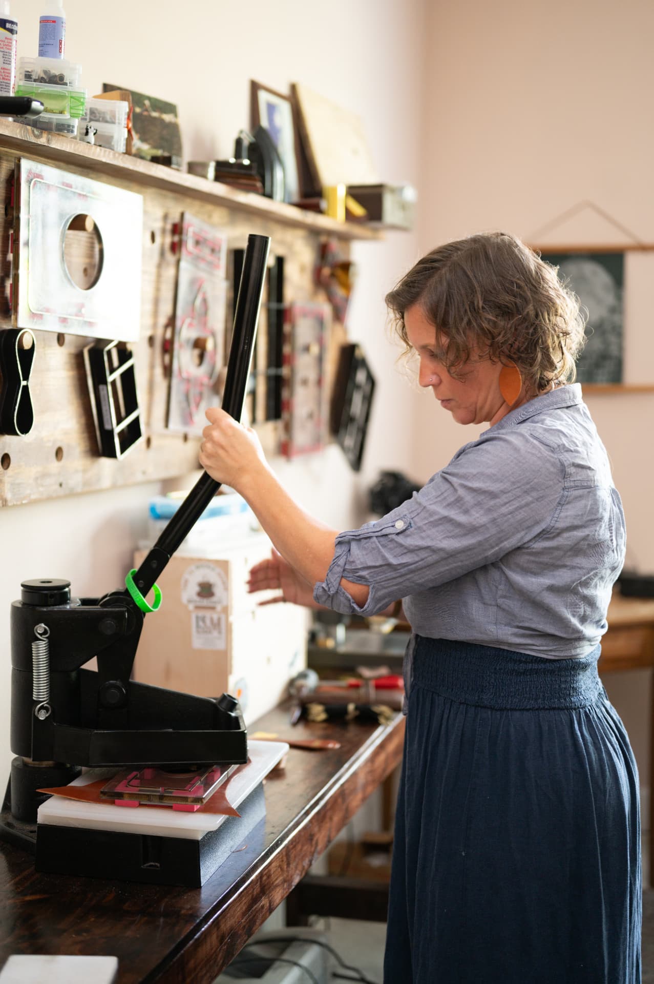Sarah reaching for a custom die on the tool wall
